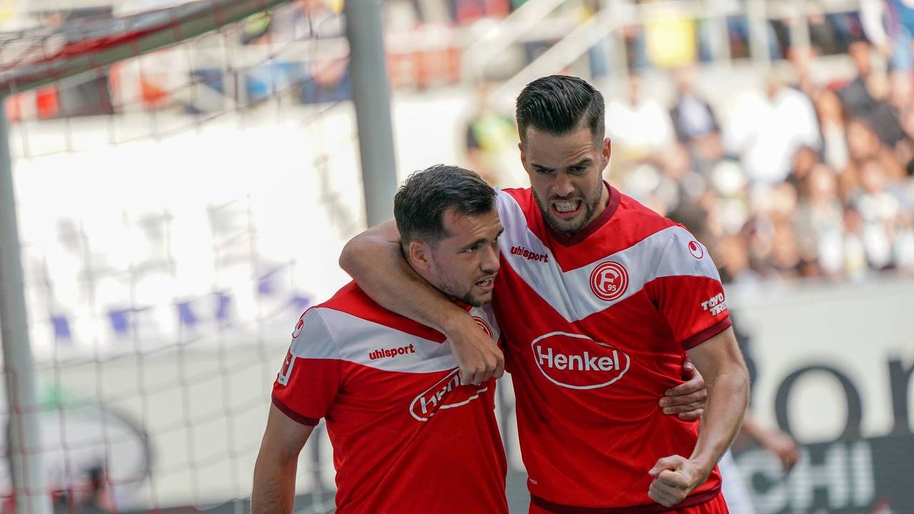 Die Düsseldorfer Niko Gießelmann und Kevin Stöger jubeln im Bundesliga-Spiel gegen Borussia Mönchengladbach.