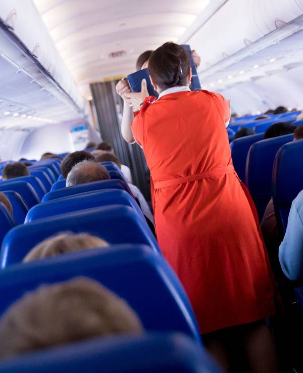Flugbegleiterinnen verteilen an Bord eines Airbus A320 Getränke und einen kleinen Snack an die Fluggäste.