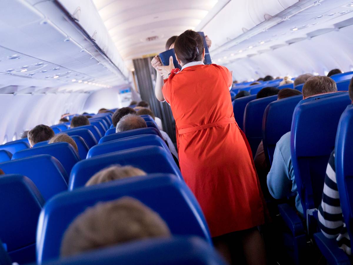 Flugbegleiterinnen verteilen an Bord eines Airbus A320 Getränke und einen kleinen Snack an die Fluggäste.