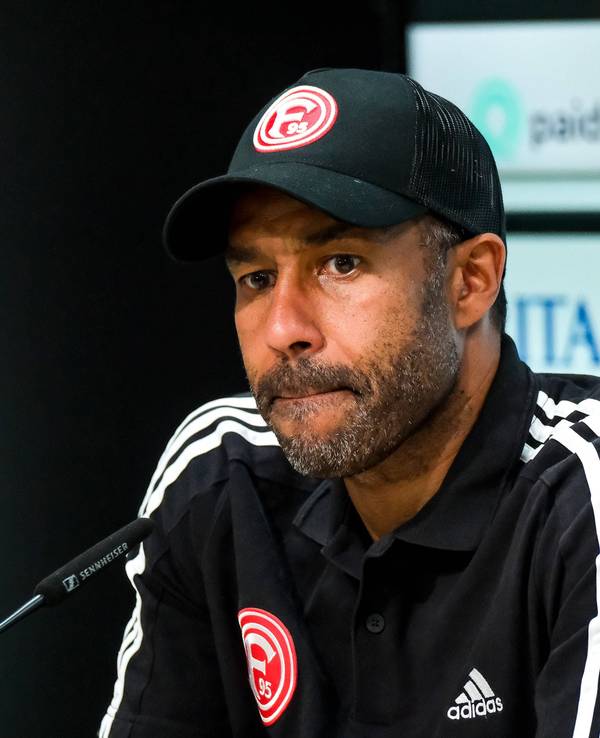 Fortuna Düsseldorfs Trainer Daniel Thioune sitzt bei der Pressekonferenz nach dem Spiel bei Wehen Wiesbaden auf dem Podium.