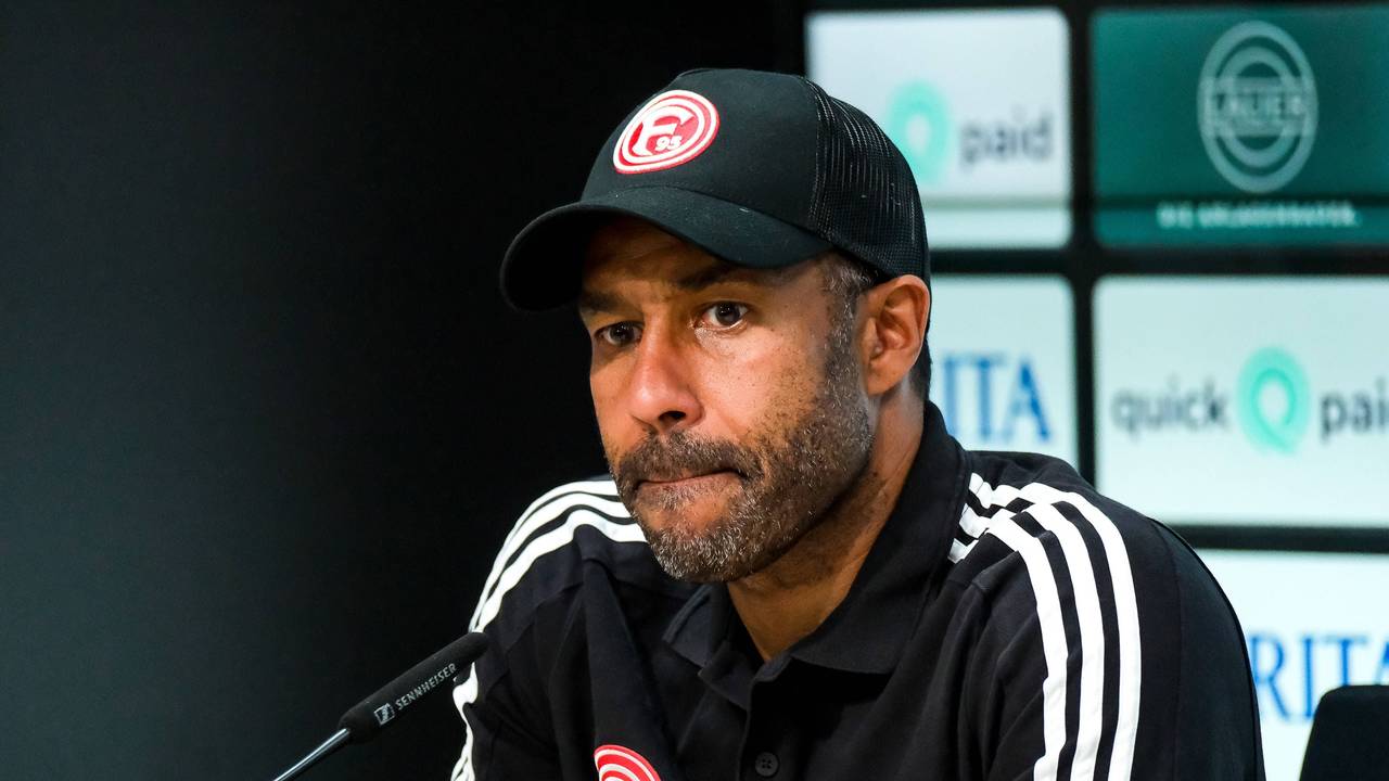 Fortuna Düsseldorfs Trainer Daniel Thioune sitzt bei der Pressekonferenz nach dem Spiel bei Wehen Wiesbaden auf dem Podium.