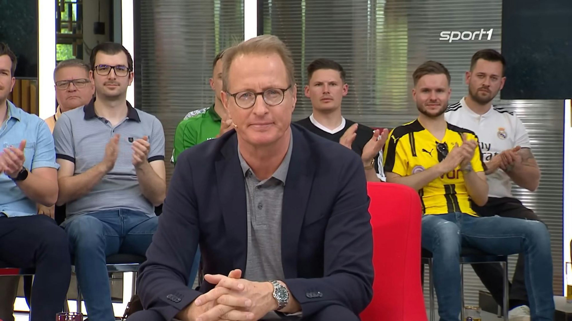 Florian König sitzt im Doppelpass auf Sport1.