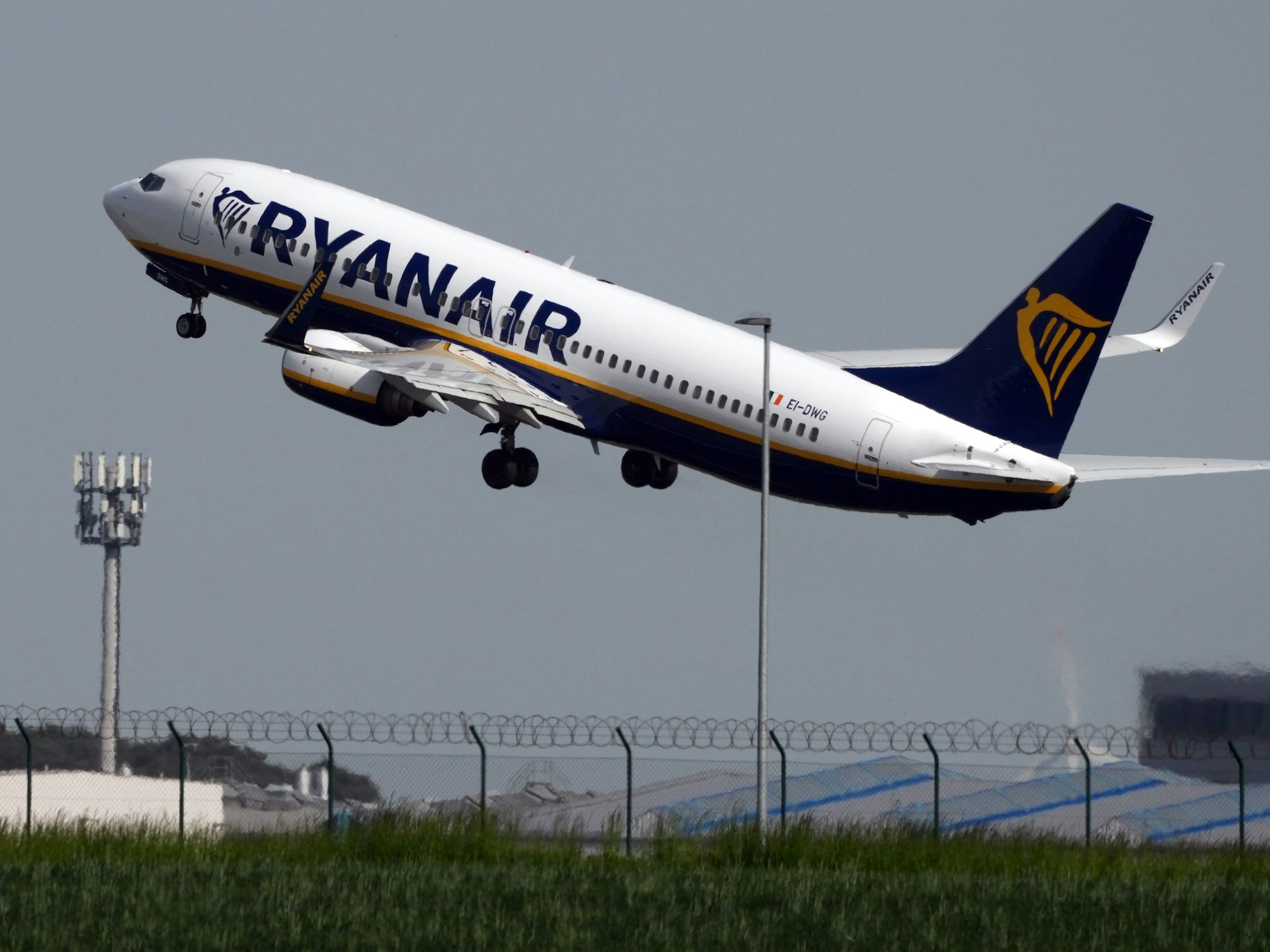 Eine Boeing 737 der Fluggesellschaft Ryanair startet hinter einer grünen Wiese vom Flughafen Berlin-Brandenburg (BER) „Willy Brandt“, hier im Mai 2023.