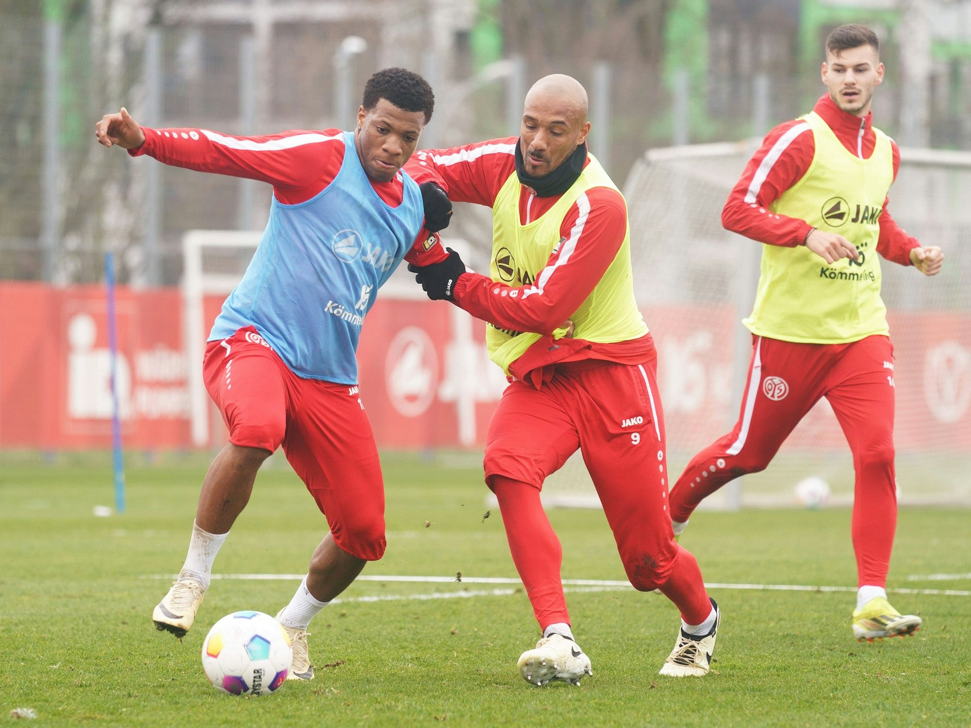 Jessic Ngankam behauptet den Ball im Mainz-Training gegen Karim Onisiwo. Tom Krauß schaut zu.