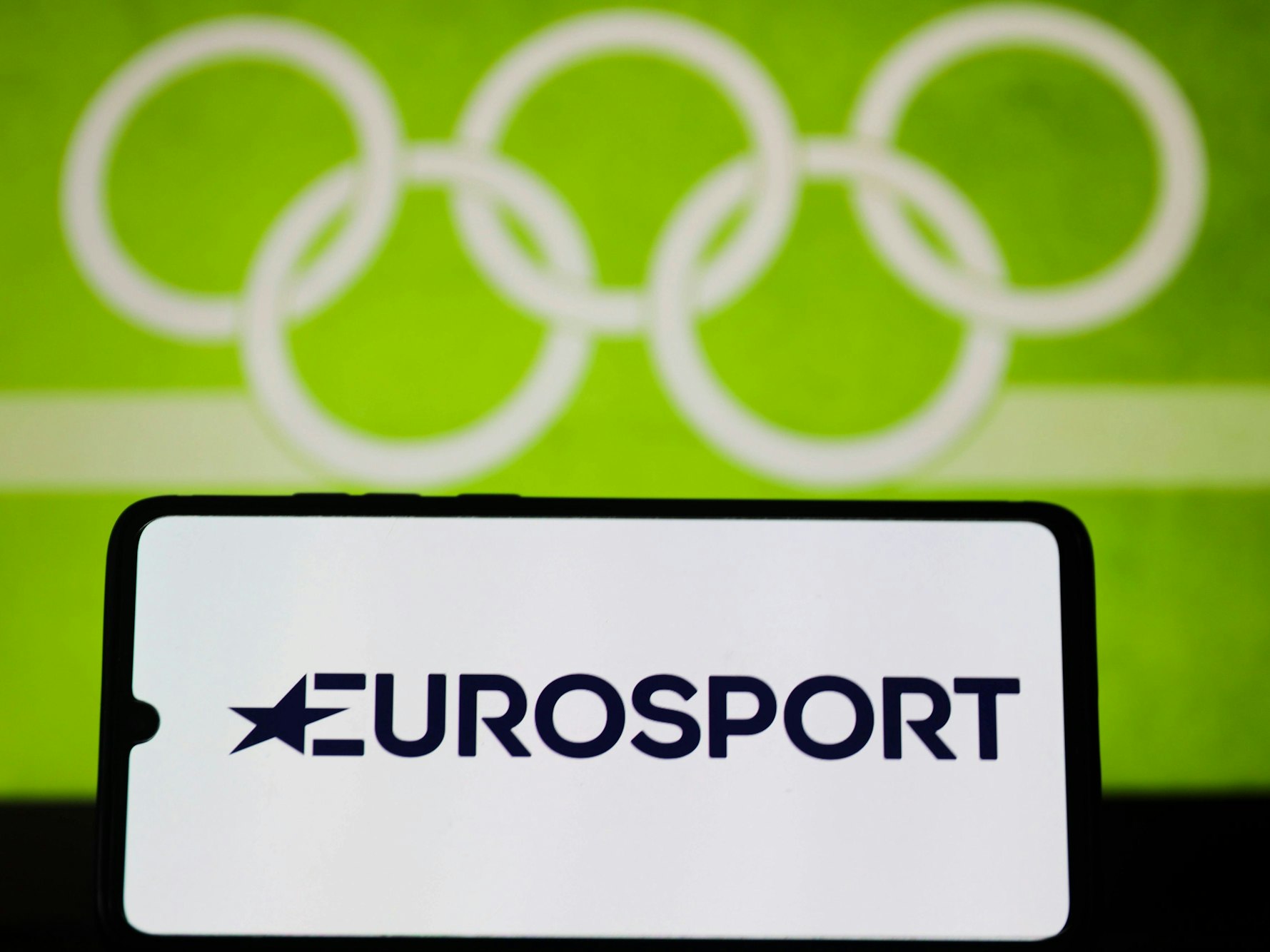 Ein Handy mit dem Eurosport-Logo vor den Olympischen Ringen.
