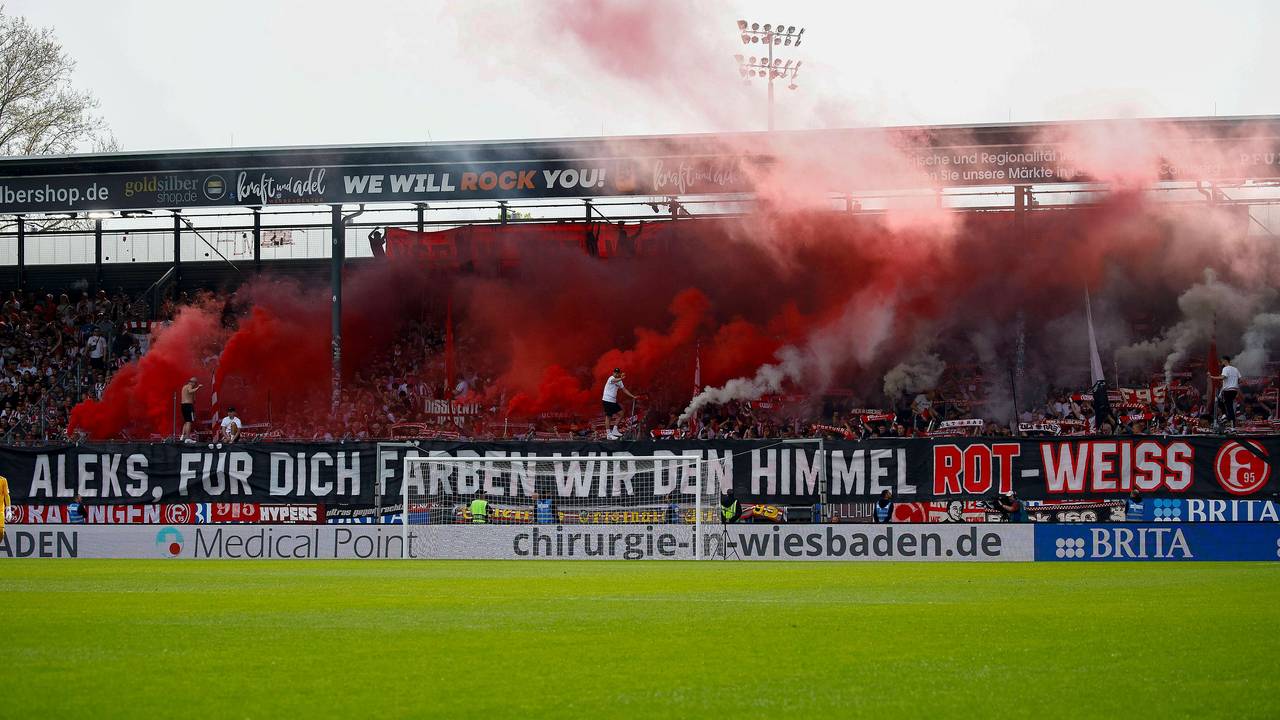 Die Fans von Fortuna Düsseldorf zeigen beim Spiel in Wiesbaden ein Banner für den verstorbenen Mannschaftsbetreuer Aleksandar Spengler.
