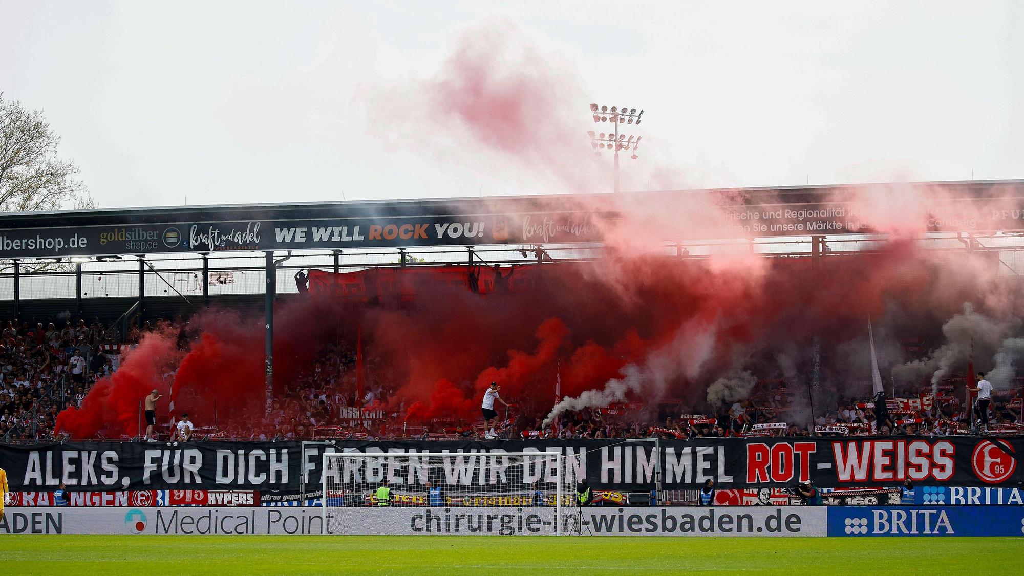Die Fans von Fortuna Düsseldorf zeigen beim Spiel in Wiesbaden ein Banner für den verstorbenen Mannschaftsbetreuer Aleksandar Spengler.