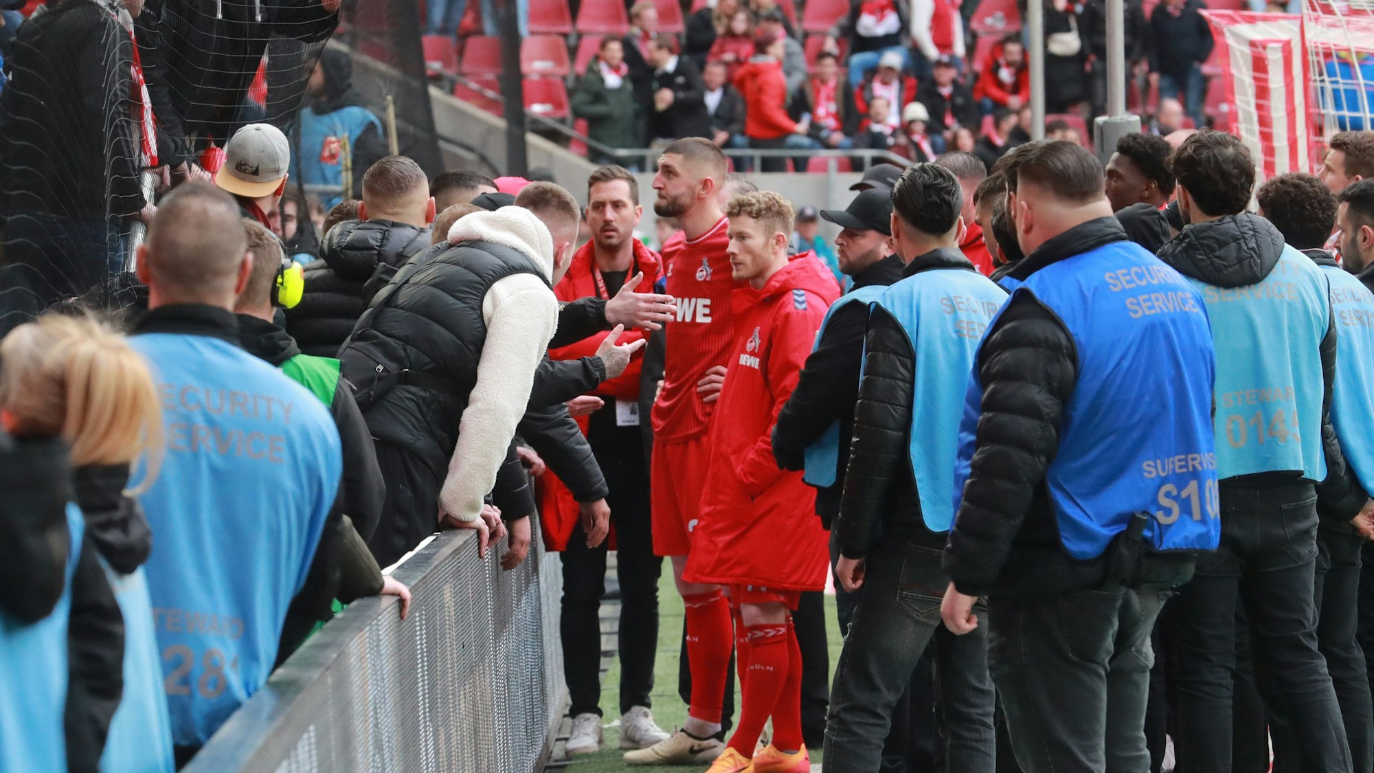 Florian Kainz und Jeff Chabot vor der Südtribüne. Ultras reden auf sie ein.