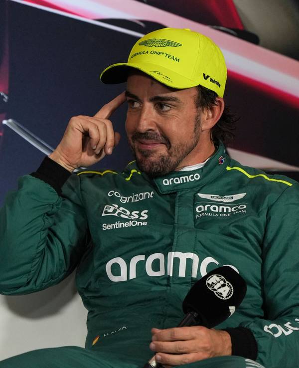 Fernando Alonso lächelt schelmisch bei einer Pressekonferenz der Formel 1.