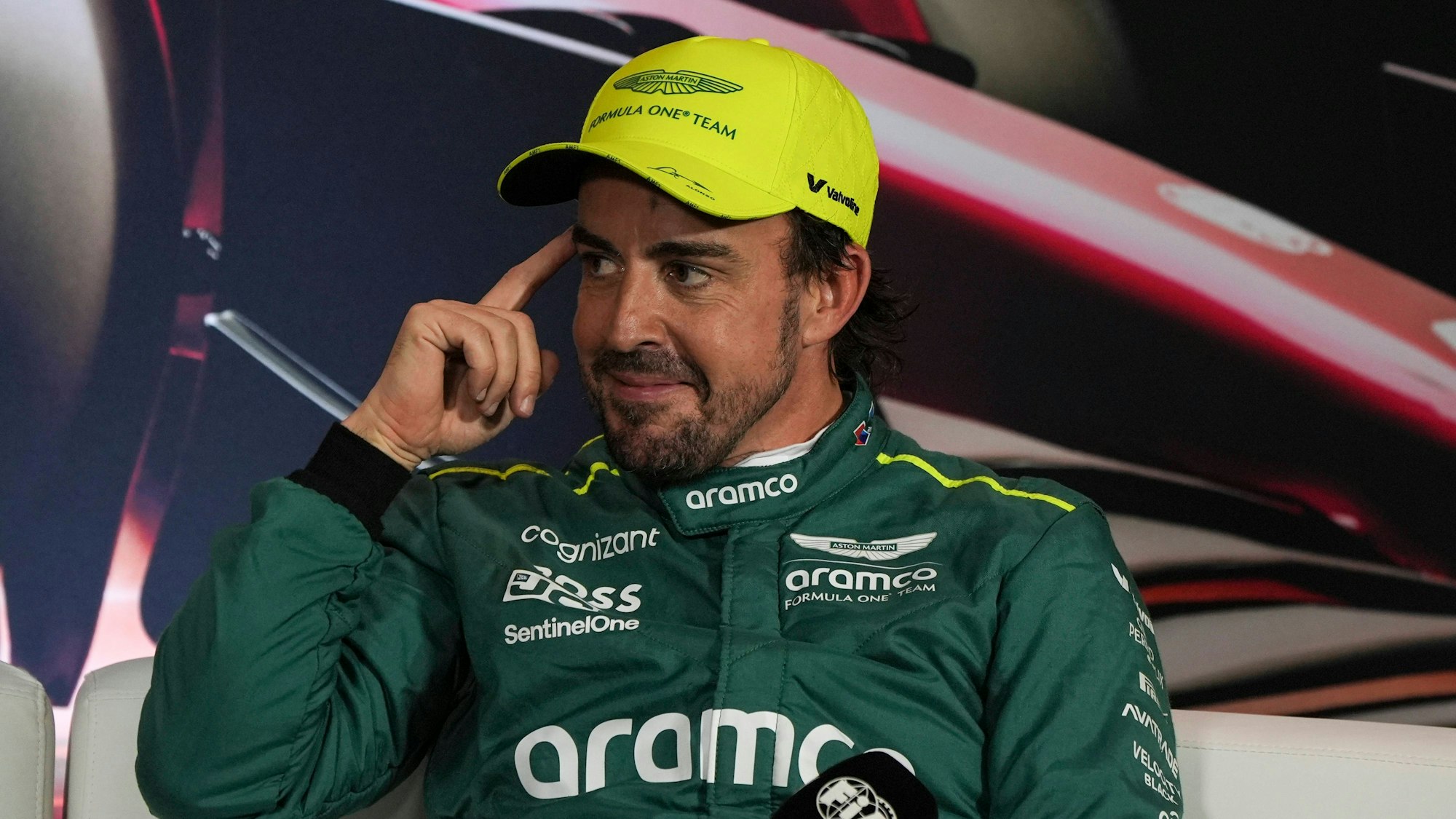 Fernando Alonso lächelt schelmisch bei einer Pressekonferenz der Formel 1.