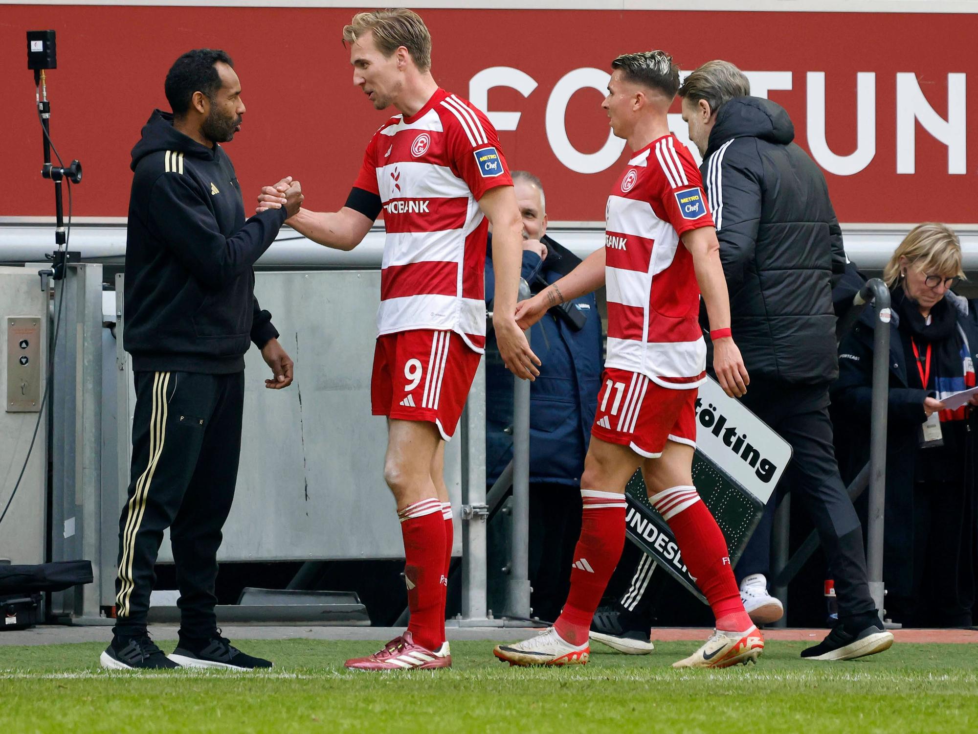 Fortuna Düsseldorfs Trainer Daniel Thioune klatscht mit seinem Stürmer Vincent Vermeij nach dessen Auswechslung im Spiel gegen Greuther Fürth ab.