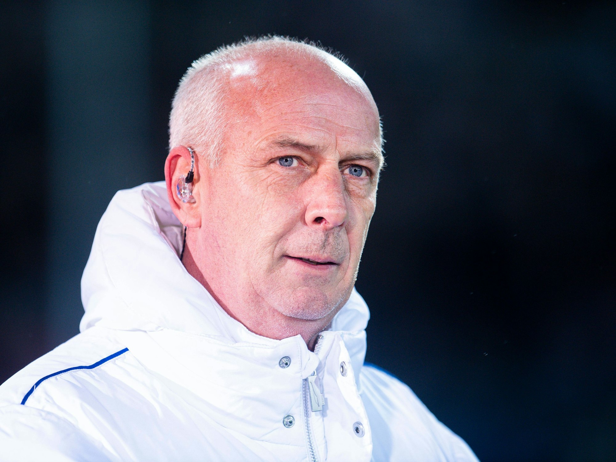 Mario Basler trägt bei einem TV-Interview Kopfhörer im Ohr.