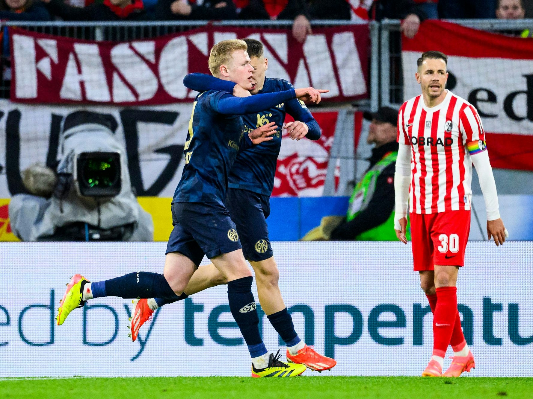 Mainz-Profi Jonathan Burkardt (l.) jubelt nach seinem Tor zum 1:1 beim SC Freiburg am Sonntag (21. April 2024) mit Mainz Brajan Gruda.