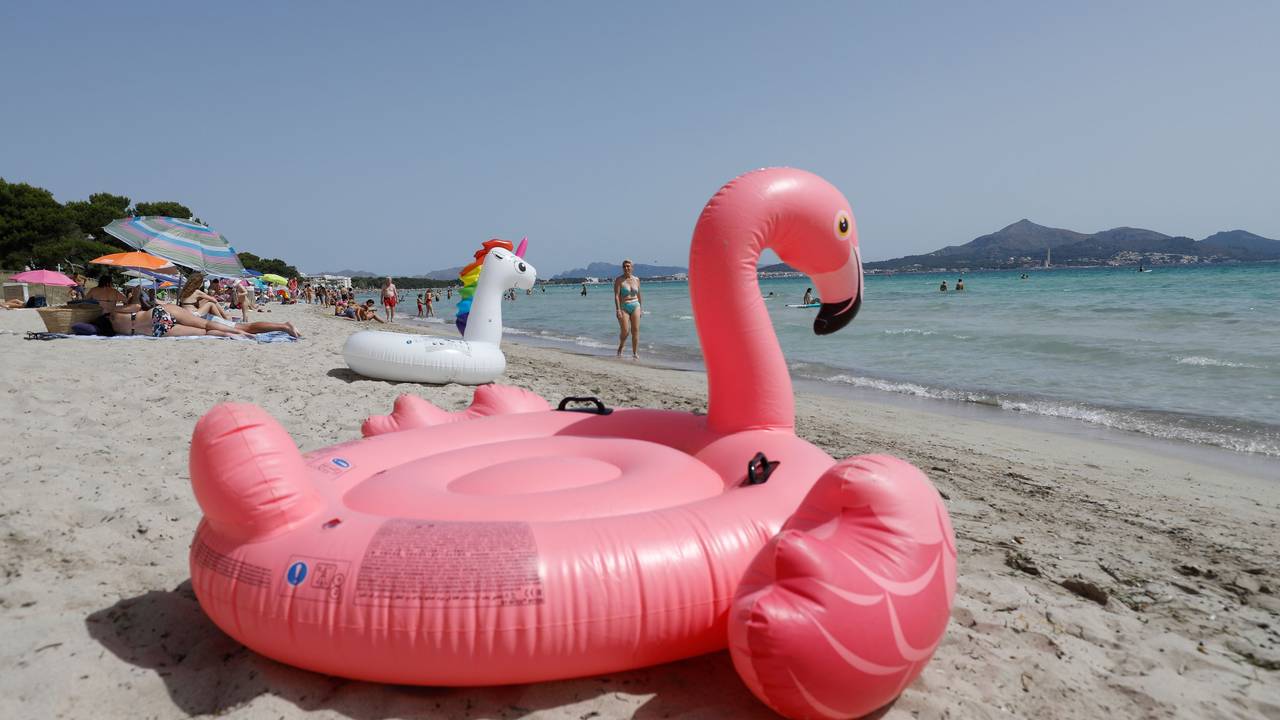 Ein aufblasbarer rosa Flamingo liegt am Strand von Playa de Muro im Norden von Mallorca.