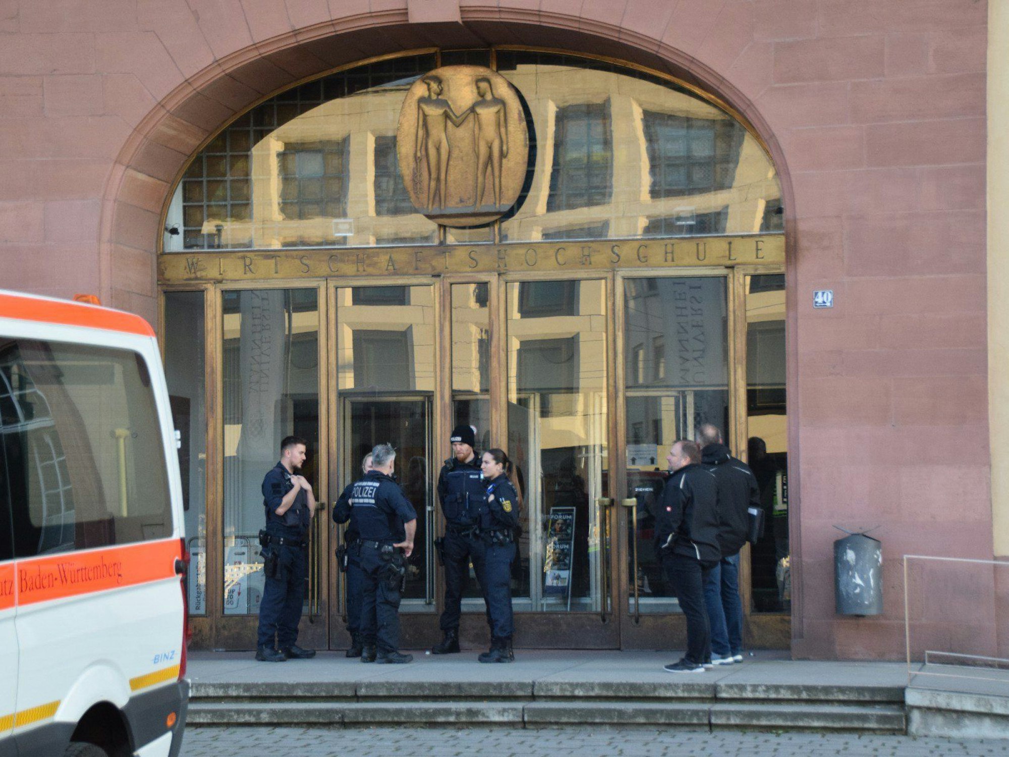 Einsatzkräfte der Polizei stehen vor der Universität in Mannheim. Die Polizei hat auf einen mutmaßlichen Randalierer in der Bibliothek der wirtschaftswissenschaftlichen Fakultät der Mannheimer Universität geschossen.