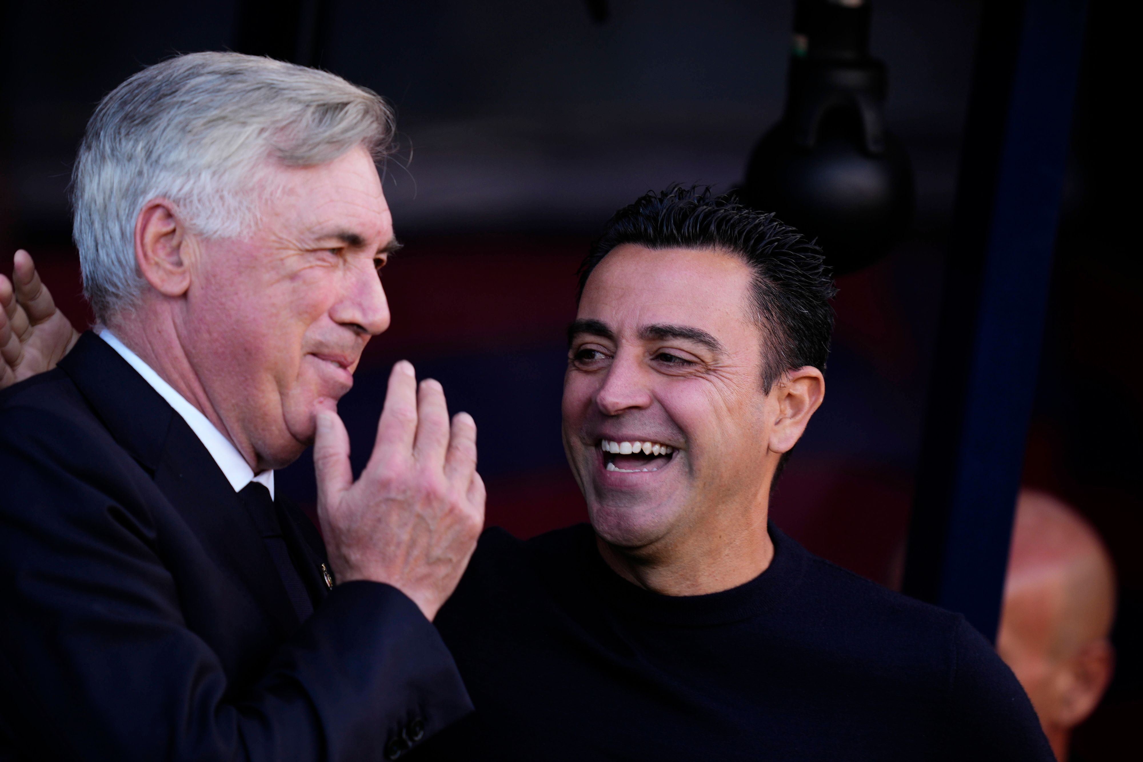 Xavi Hernandez lacht mit Carlo Ancelotti am Rande des Ligaspiels FC Barcelona gegen Real Madrid.