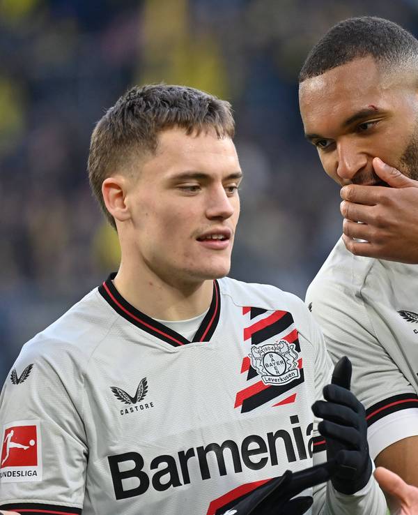 Jonathan Tah bespricht sich mit Florian Wirtz während des Bundesligaspiels von Bayer Leverkusen bei Borussia Dortmund.