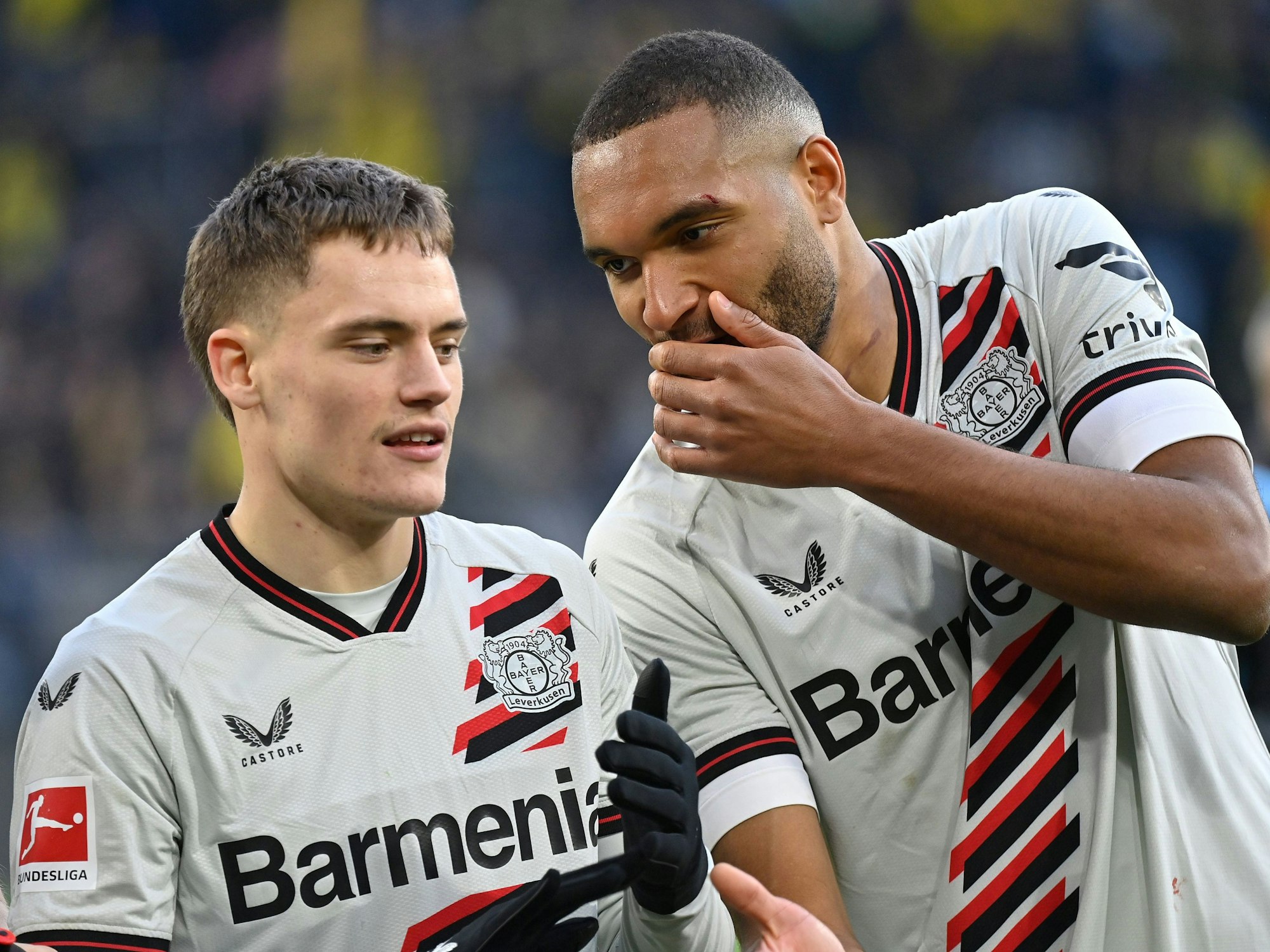 Jonathan Tah bespricht sich mit Florian Wirtz während des Bundesligaspiels von Bayer Leverkusen bei Borussia Dortmund.
