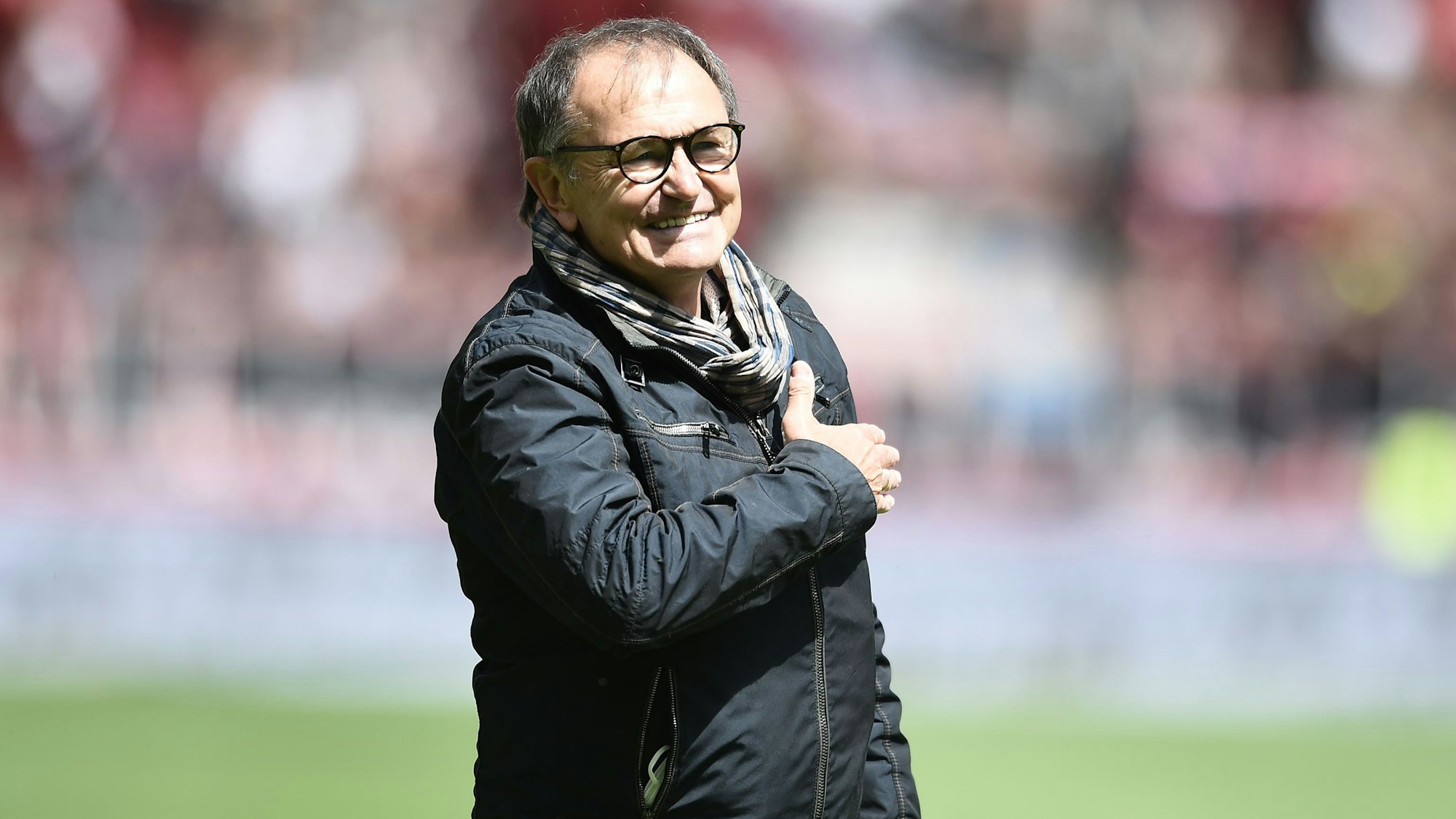 Ewald Lienen lächelt bei einem Auftritt im Stadion des FC St. Pauli.