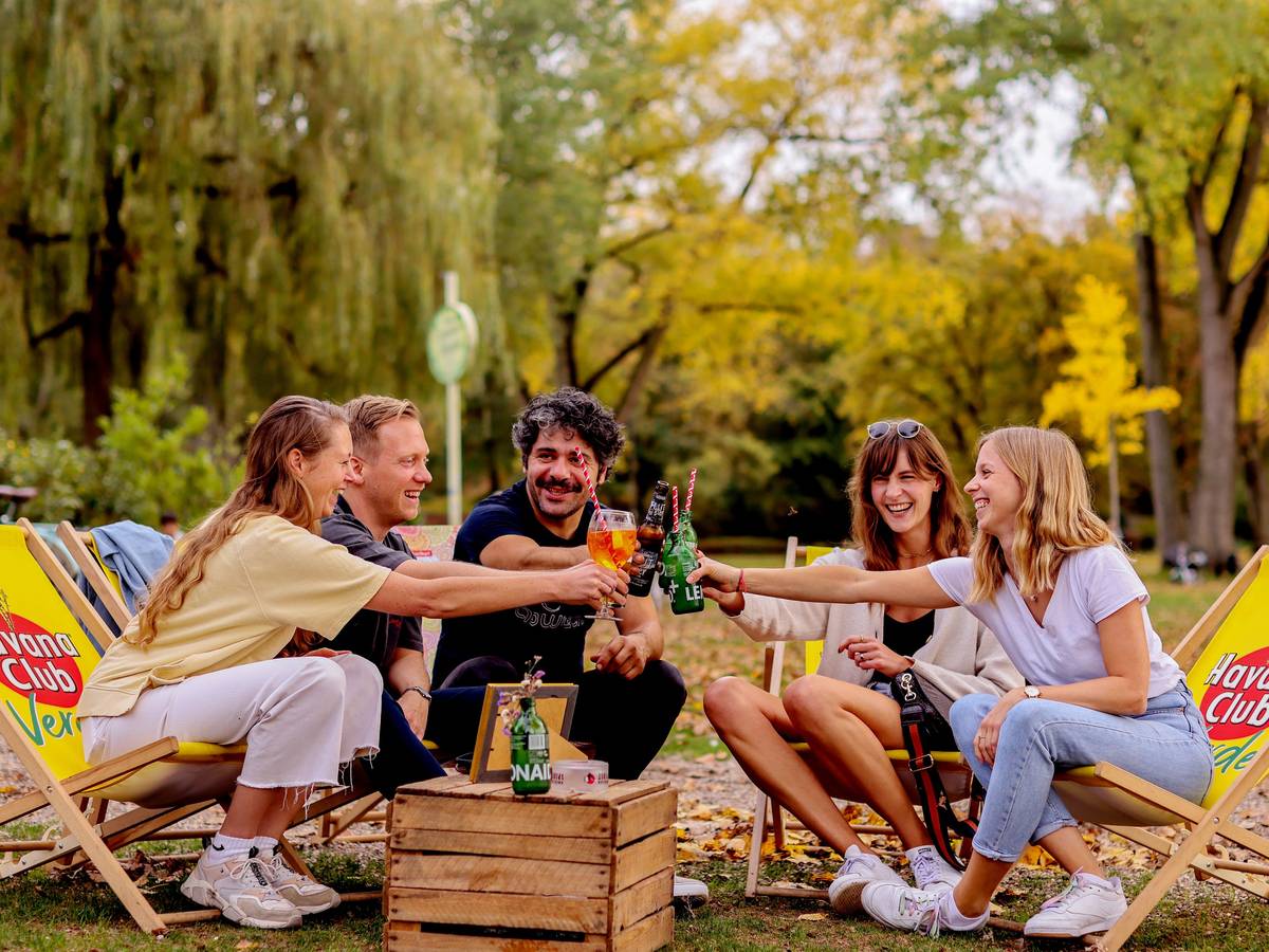 Junge Leute sitzen im Biergarten am Aachener Weiher in Köln.
