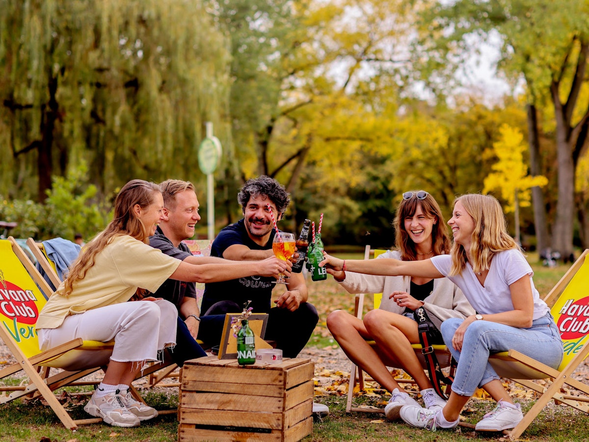 Junge Leute sitzen im Biergarten am Aachener Weiher in Köln.
