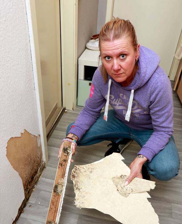 Mieterin Sarah Wolff zeigt Schimmel unter der Bodenleiste.