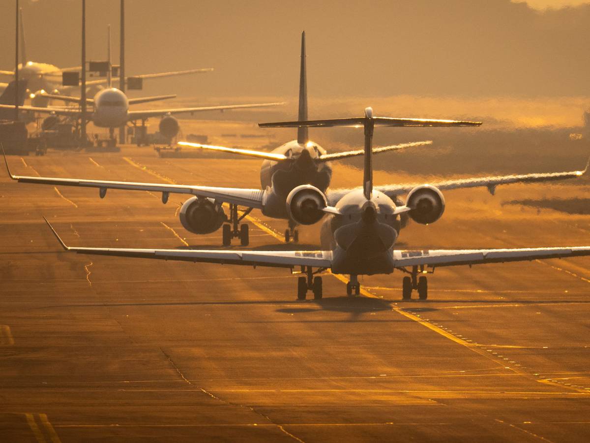 Flugzeuge rollen auf dem Flughafen Frankfurt im letzten Sonnenlicht des Tages über die Rollbahn.