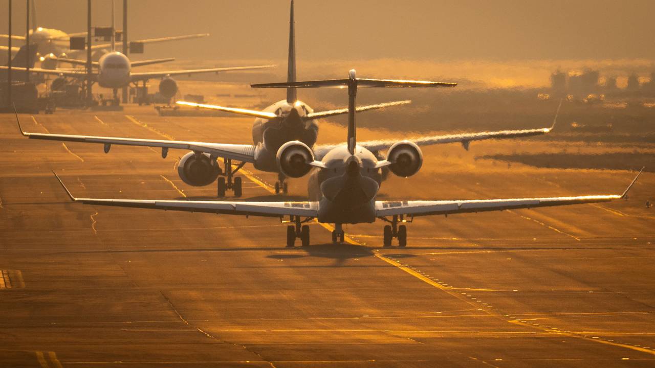 Flugzeuge rollen auf dem Flughafen Frankfurt im letzten Sonnenlicht des Tages über die Rollbahn.