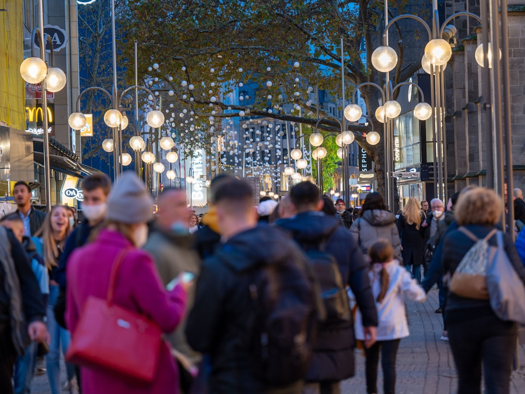 Menschen Shoppen in der Schildergasse im Abendlicht.