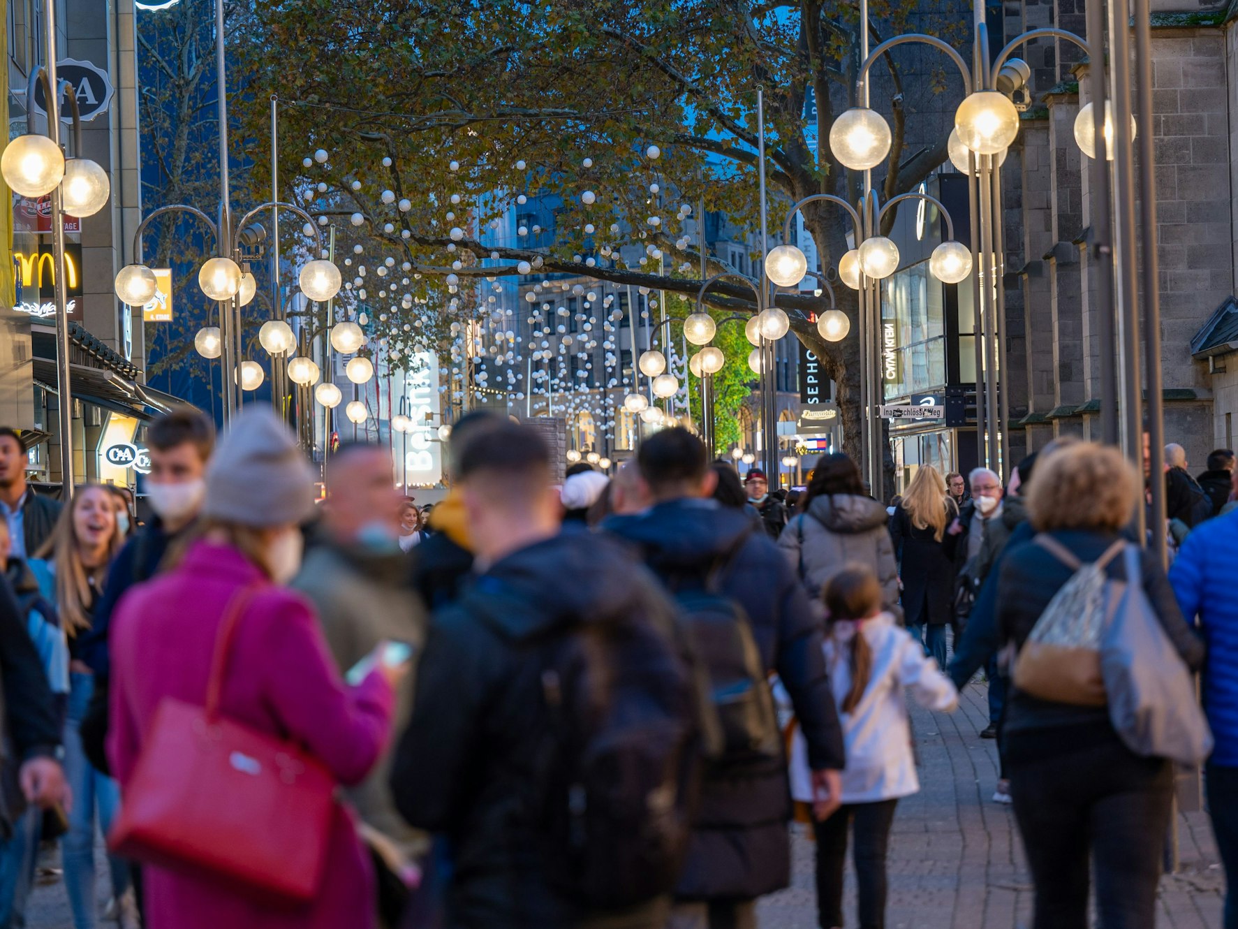 Menschen Shoppen in der Schildergasse im Abendlicht.