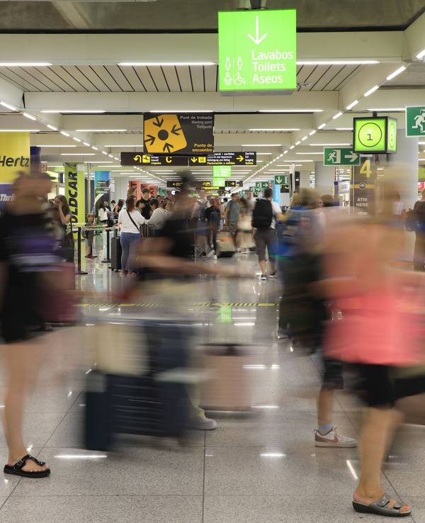 Reisende gehen am Flughafen von Mallorca durch eine Halle, hier im Juli 2023.