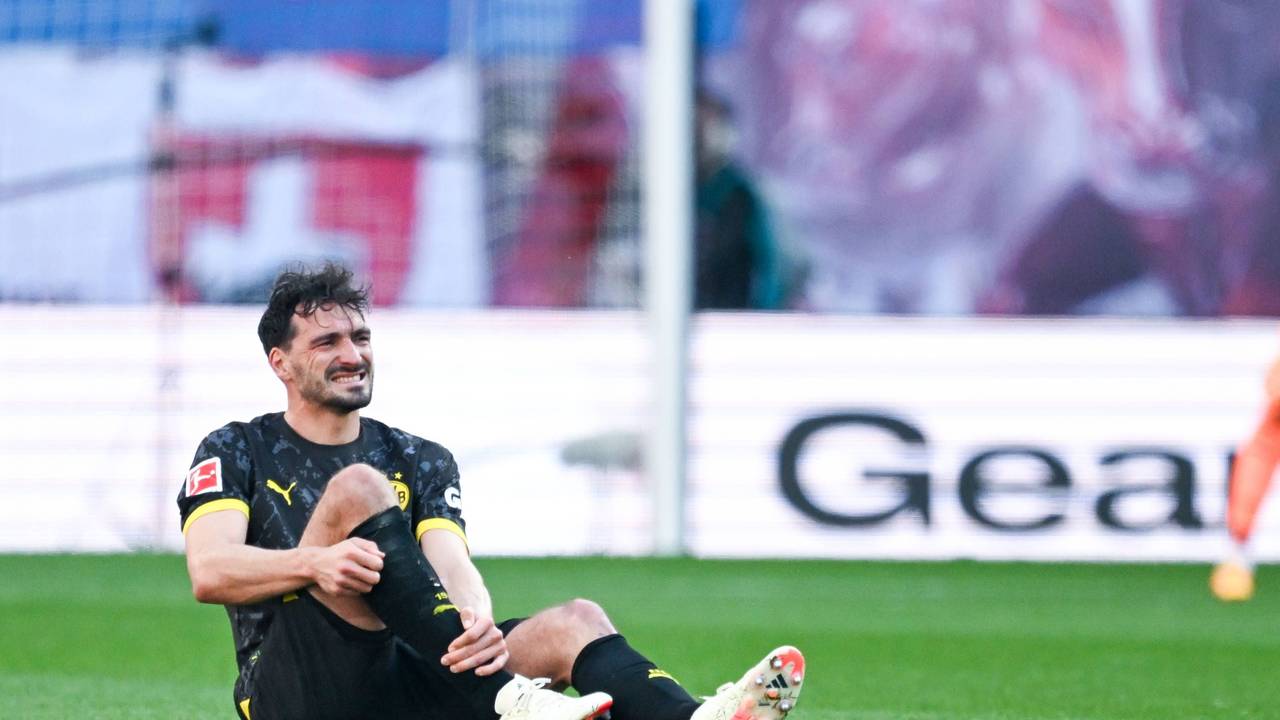 Mats Hummels sitzt mit schmerzverzerrter Miene auf dem Rasen und hält sich das rechte Schienbein.