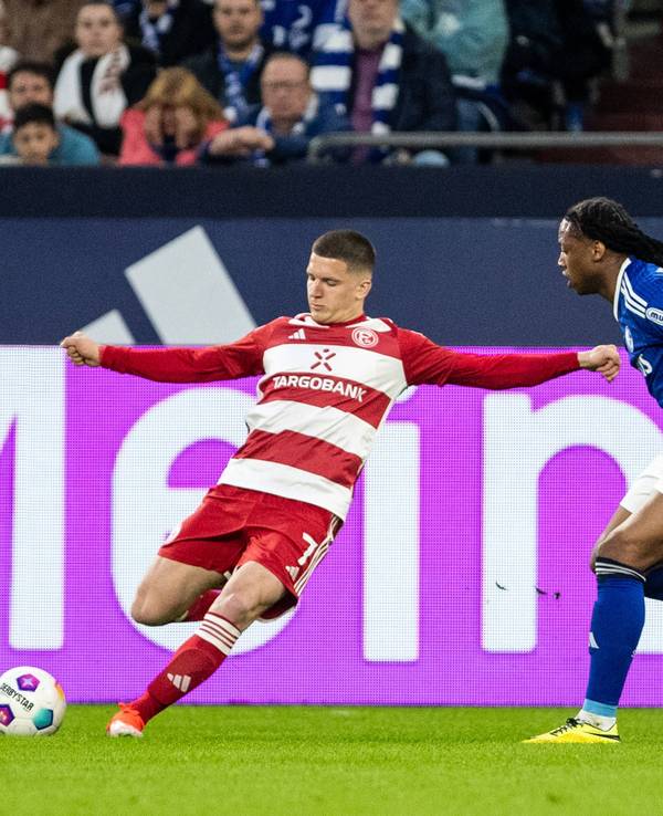 Fortuna Düsseldorfs Christos Tzolis flankt, Schalkes Brandon Soppy versucht zu blocken.