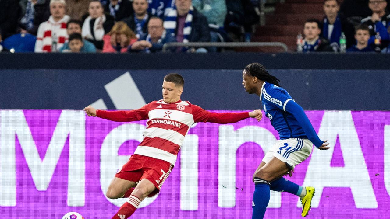 Fortuna Düsseldorfs Christos Tzolis flankt, Schalkes Brandon Soppy versucht zu blocken.