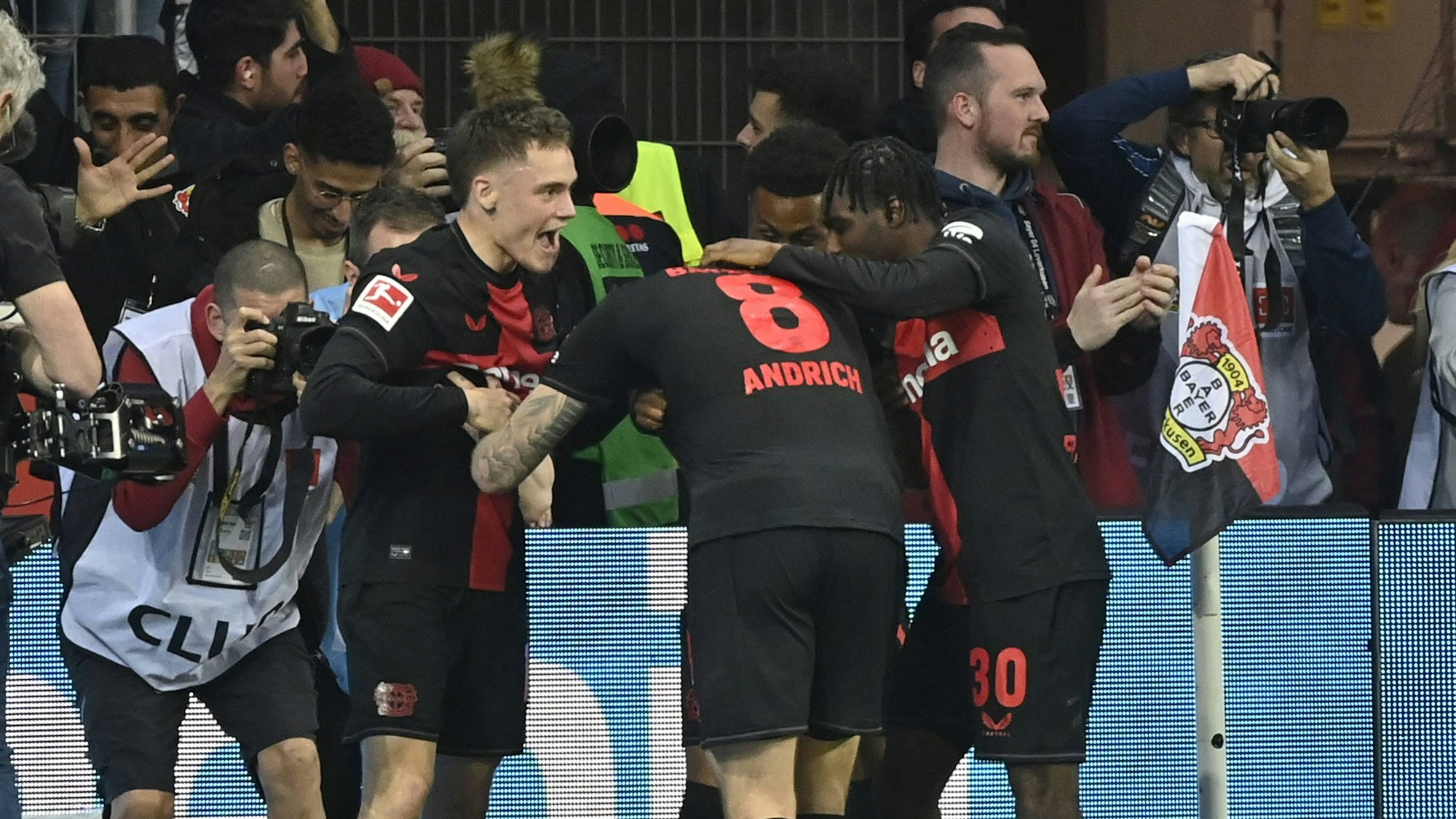 Robert Andrich wird von den Teamkollegen für seinen Ausgleichs-Treffer beim Spiel zwischen Bayer Leverkusen und dem VfB Stuttgart gefeiert.