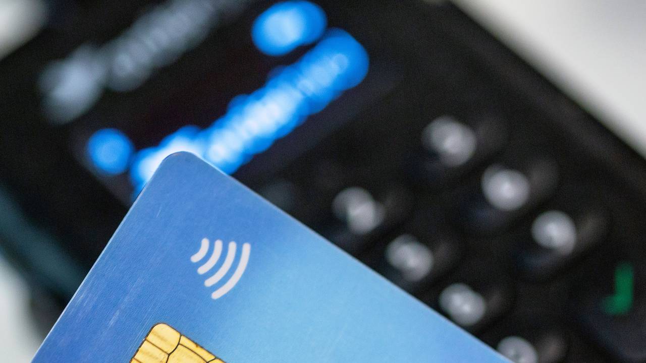 Eine Person hält ihre Bankkarte über ein EC-Lesegerät zwecks kontaktlosem Bezahlen, hier im Juni 2023 in Berlin.