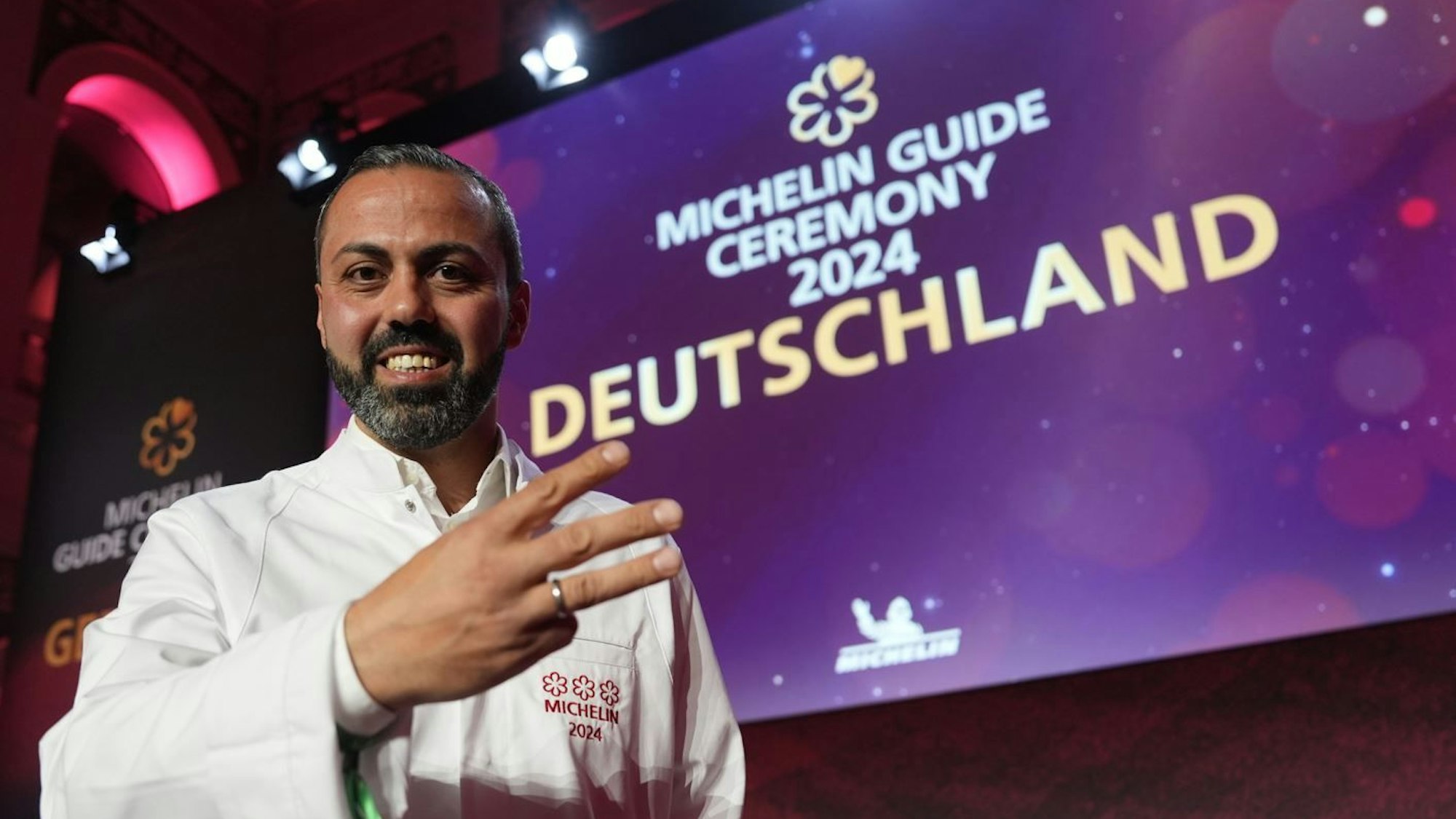 Sternekoch Edip Sigl zeigt drei Finger für drei Sterne.