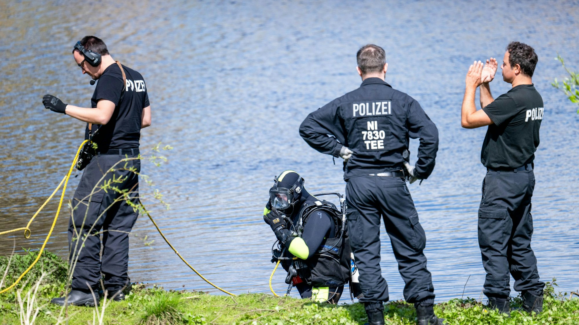 Ein Taucher der Polizei steigt in die Oste. Der sechs Jahre alte Arian aus Elm wird weiter vermisst.