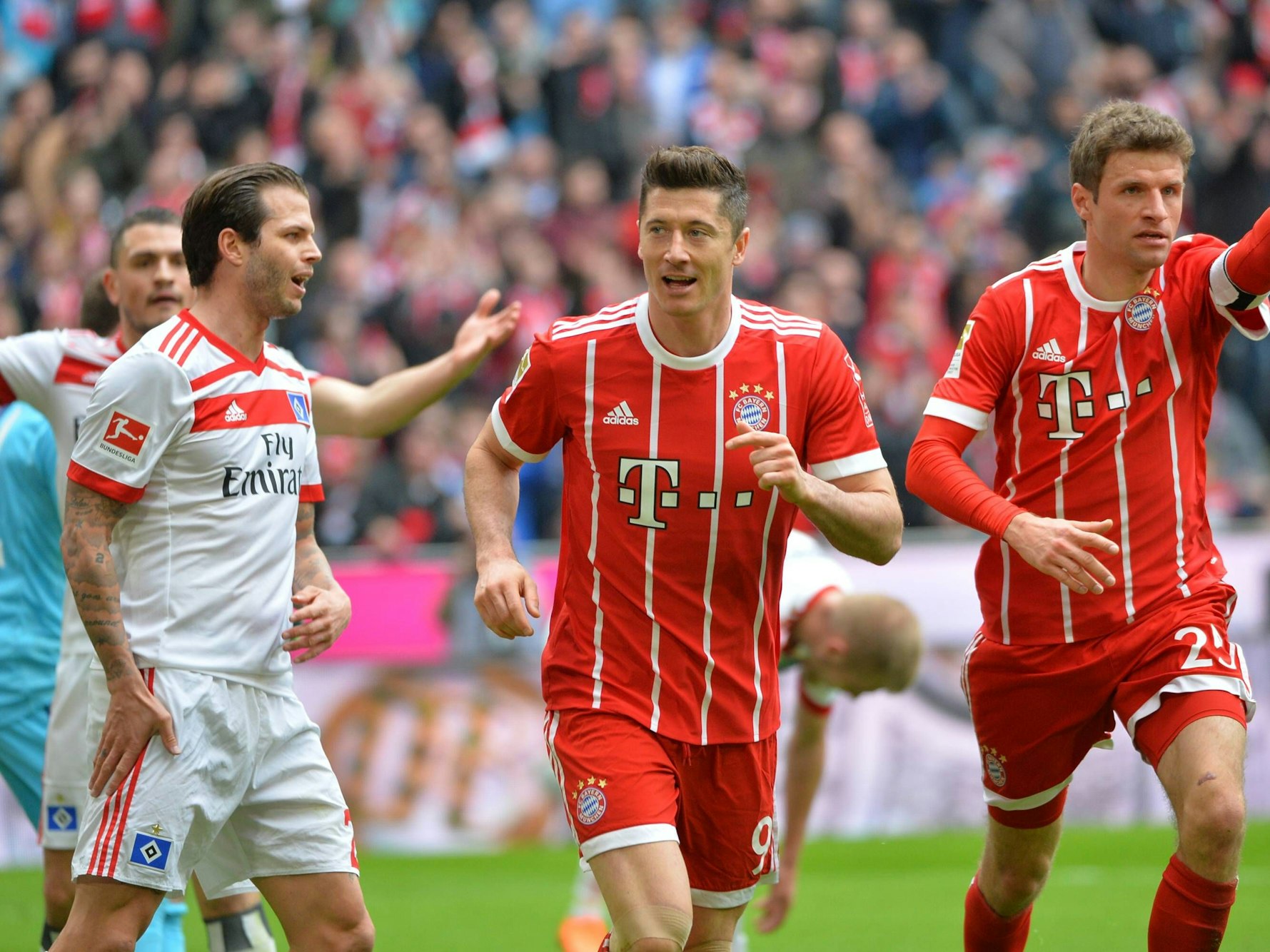 Dennis Diekmeier schaut nach einem Tor von Robert Lewandowski, Thomas Müller jubelt mit.