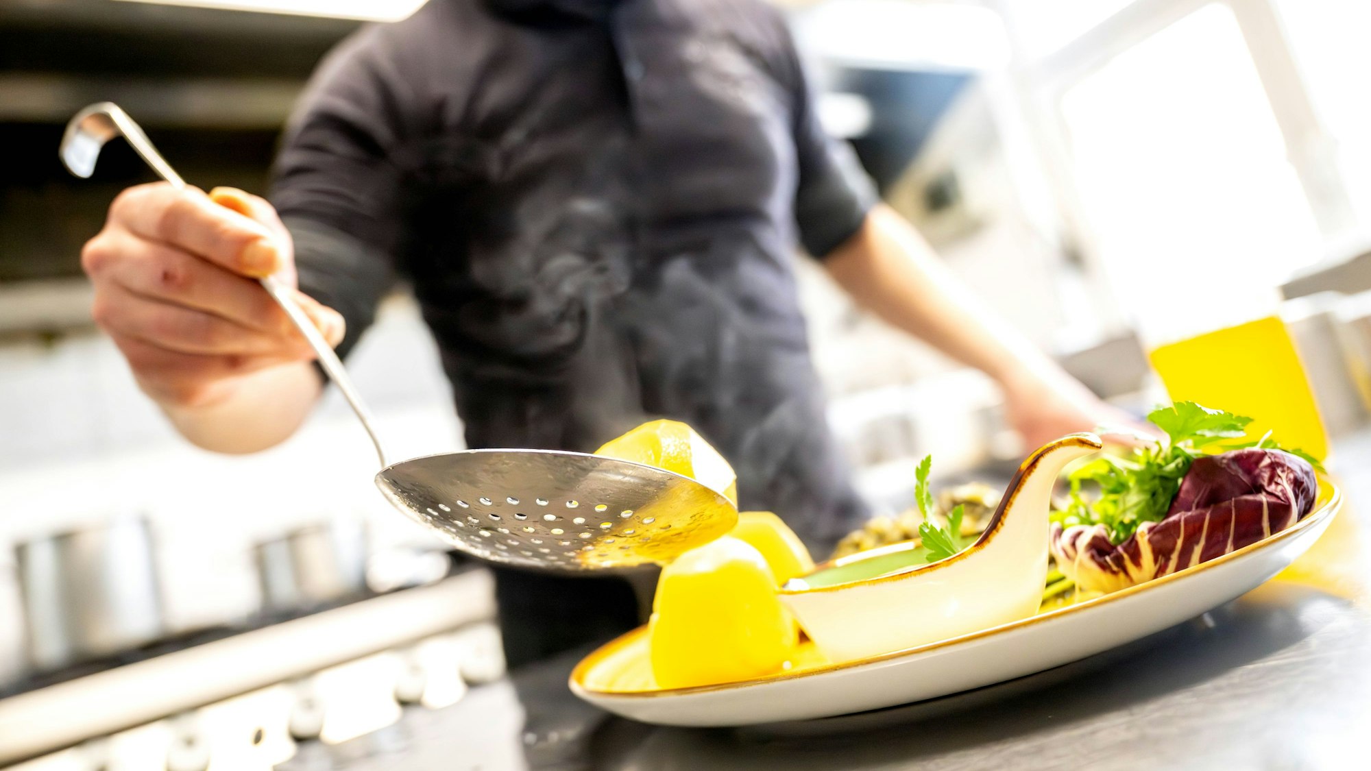 Essen wird in einem Restaurant auf einem Teller angerichtet.