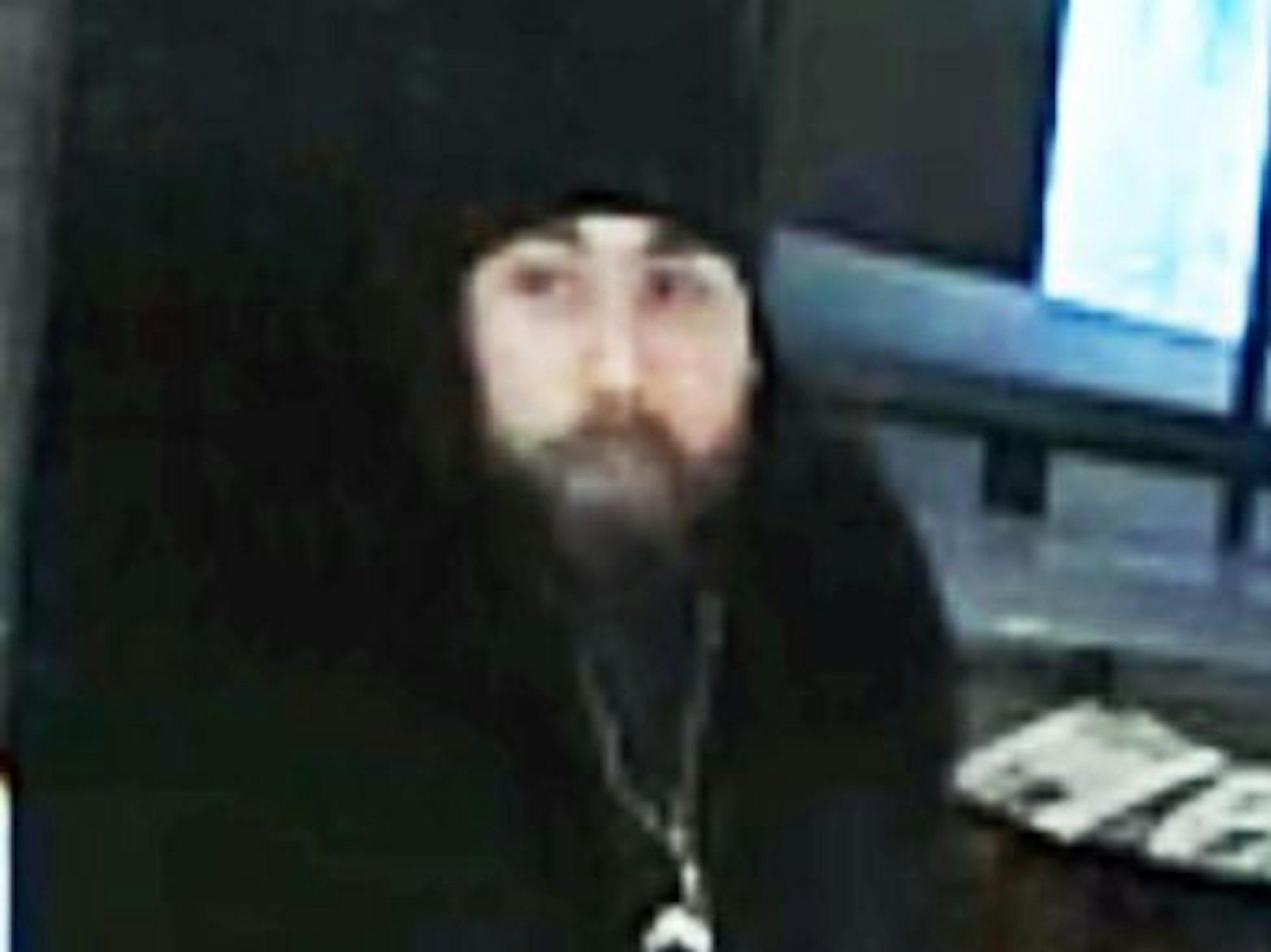 Fahndungsfoto eines Mannes mit schwarzer Mütze und schwarzen Klamotten.