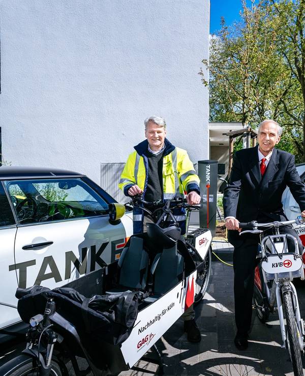 Jörn Hansen (TankE, links), Bernd Gräber (GAG, Mitte) und Frank Wendler (KVB, rechts) eröffnen den Mobilitäts-Hub mit Ladesäulen für E-Pkw, KVB-Rädern und GAG-Lastenrad in der Kannebäckersiedlung in Humbold/Gremberg.