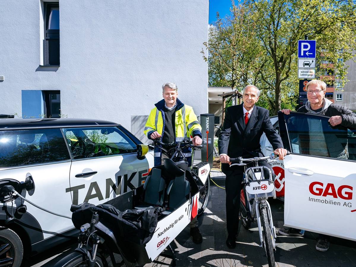 Jörn Hansen (TankE, links), Bernd Gräber (GAG, Mitte) und Frank Wendler (KVB, rechts) eröffnen den Mobilitäts-Hub mit Ladesäulen für E-Pkw, KVB-Rädern und GAG-Lastenrad in der Kannebäckersiedlung in Humbold/Gremberg.