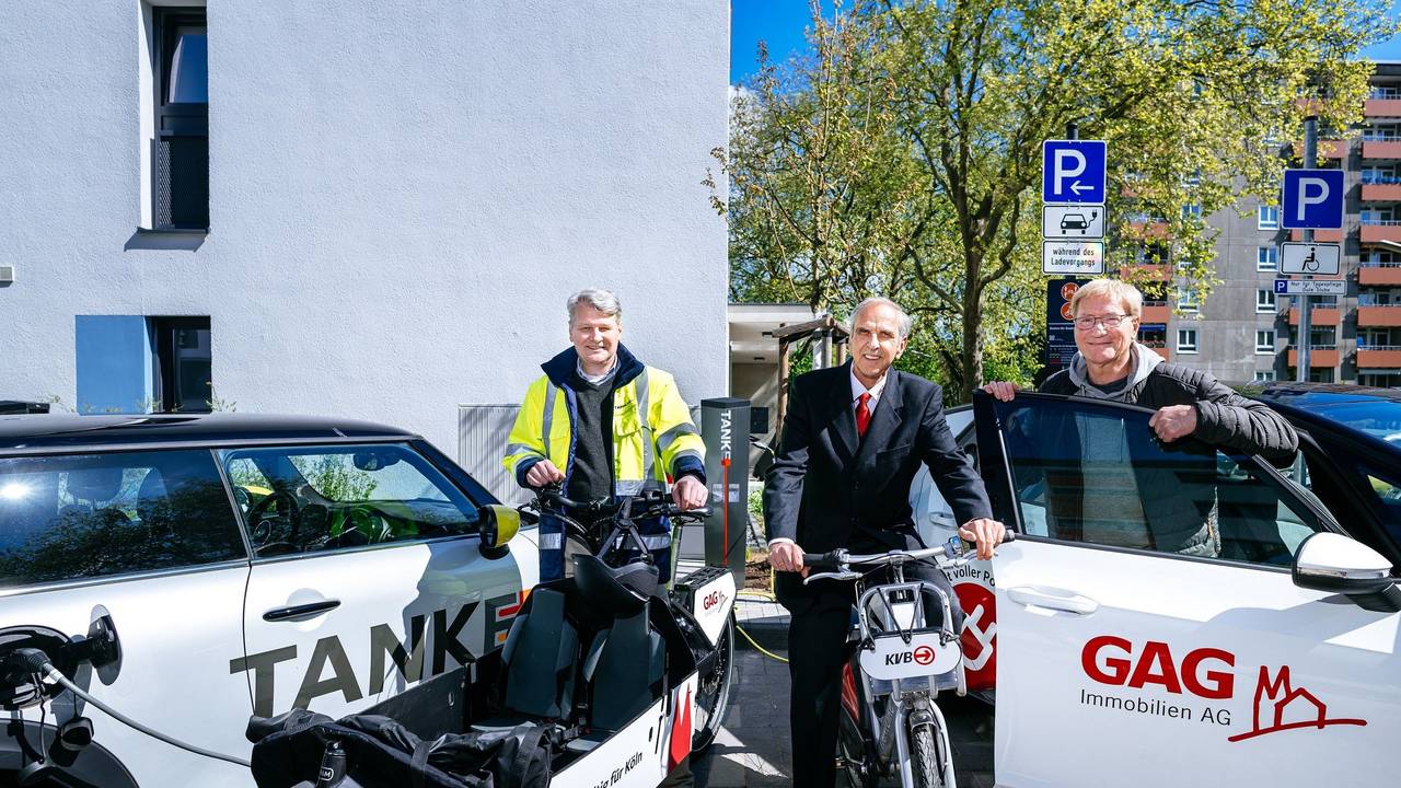 Jörn Hansen (TankE, links), Bernd Gräber (GAG, Mitte) und Frank Wendler (KVB, rechts) eröffnen den Mobilitäts-Hub mit Ladesäulen für E-Pkw, KVB-Rädern und GAG-Lastenrad in der Kannebäckersiedlung in Humbold/Gremberg.