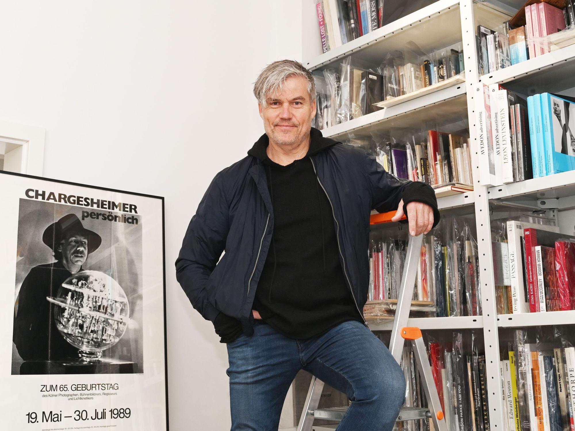 Ecki Heuser steht vor einem Bücherregal.