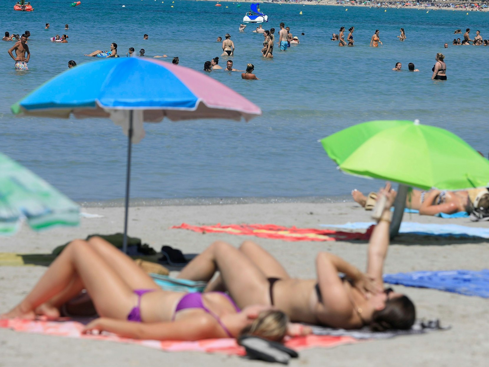 ARCHIV - 23.08.2023, Spanien, Palma: Menschen verbringen einen Sommertag am Strand Arenal. (zu dpa: «Höhere Ticketsteuer belastet Urlauber und Tourismus-Branche») Foto: Clara Margais/dpa +++ dpa-Bildfunk +++