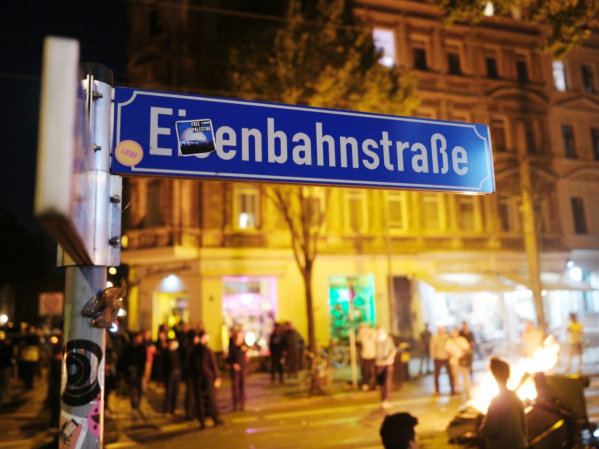 Das Straßenschild der Eisenbahnstraße in Leipzig vor einer brennende Barrikade. Bei einer linken Protestaktion gegen die Räumung eines besetzten Hauses kam es im September 2023 zu Ausschreitungen.