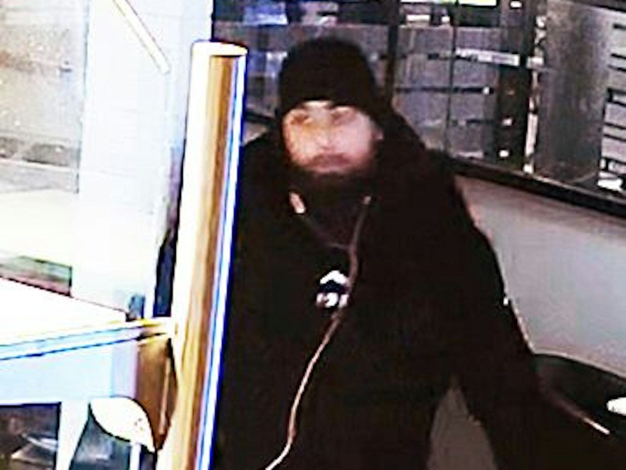 Fahndungsfotos eines Mannes mit schwarzer Mütze und schwarzem Pullover.