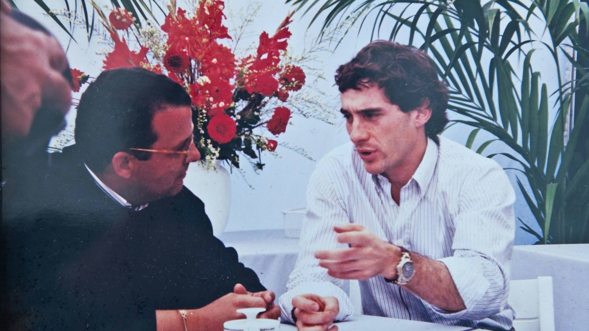 Ayrton Senn im Gespräch mit Domingos Piedade, beide sitzen an einem Tisch.