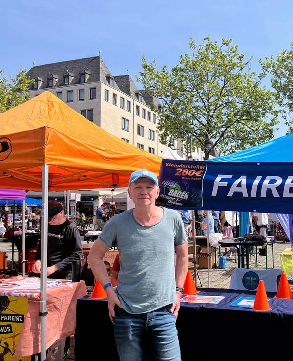 Klaus Stutzer steht vor dem Stand der Initiative „Faire Gagen“.